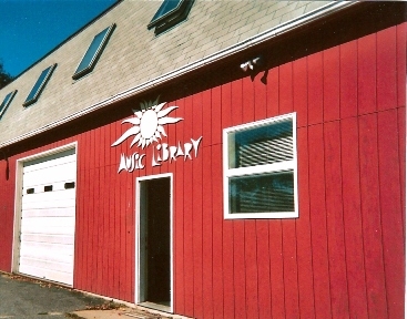 A red barn with a white sun sign on it.